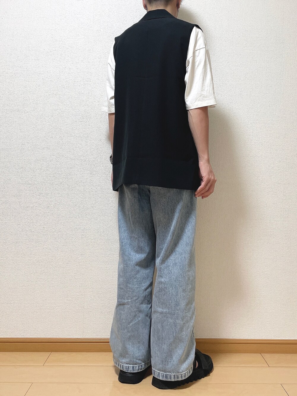 ブラック系のベスト、ホワイト系のTシャツ/カットソー、ブルー系のデニムパンツを着用したメンズの夏コーディネートの4枚目の写真
