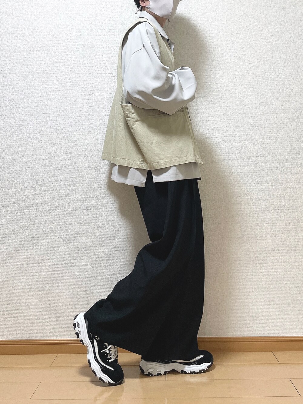 ベージュ系のベスト、グレー系のシャツ/ブラウス、ブラック系のスラックスを着用したメンズの春コーディネートの2枚目の写真