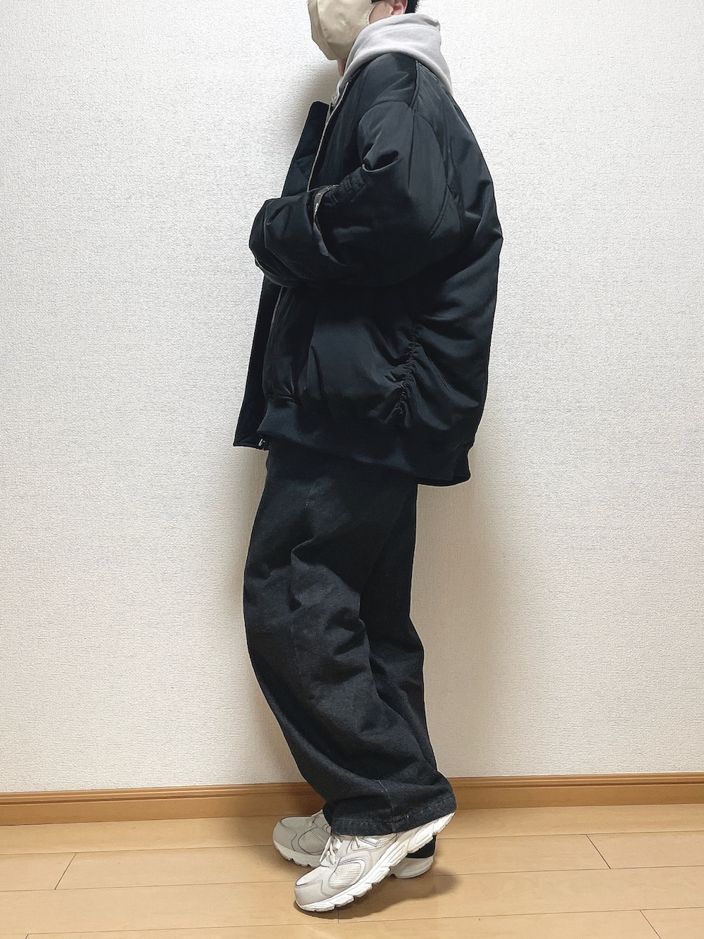 ブラック系のMA-1、グレー系のパーカー、ブラック系のデニムパンツを着用したメンズの冬コーディネートの3枚目の写真