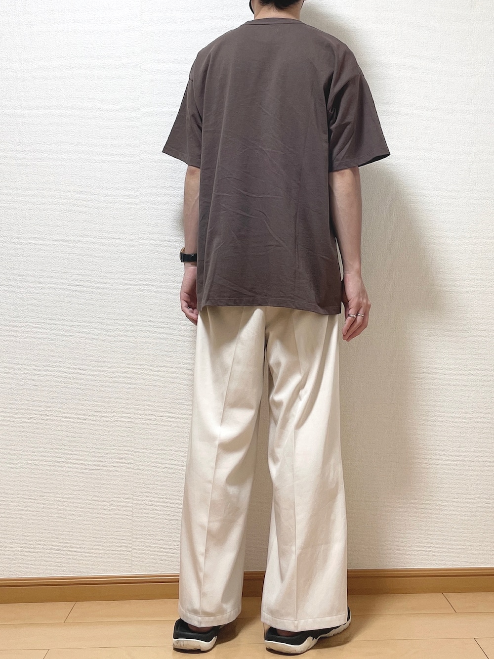 ブラウン系のTシャツ/カットソー、ベージュ系のスラックス、ブラック系のサンダルを着用したメンズの夏コーディネートの4枚目の写真