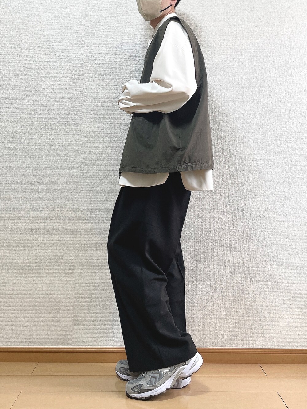 グレー系のベスト、ホワイト系のシャツ/ブラウス、ブラック系のスラックスを着用したメンズの春コーディネートの3枚目の写真