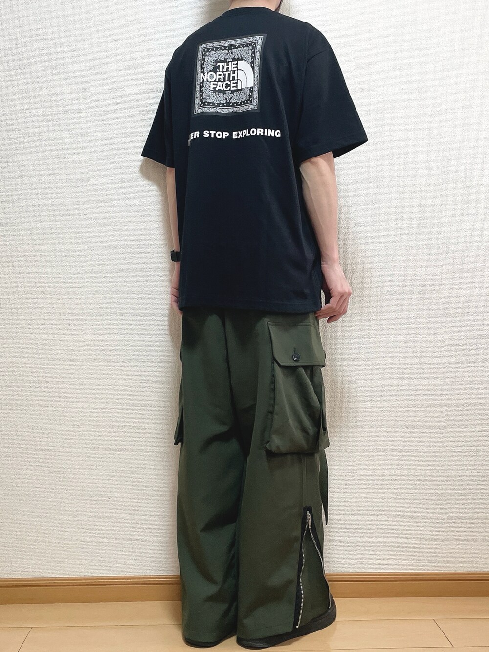 ブラック系のTシャツ/カットソー、グリーン系のカーゴパンツ、ブラック系のスニーカーを着用したメンズの春コーディネートの4枚目の写真