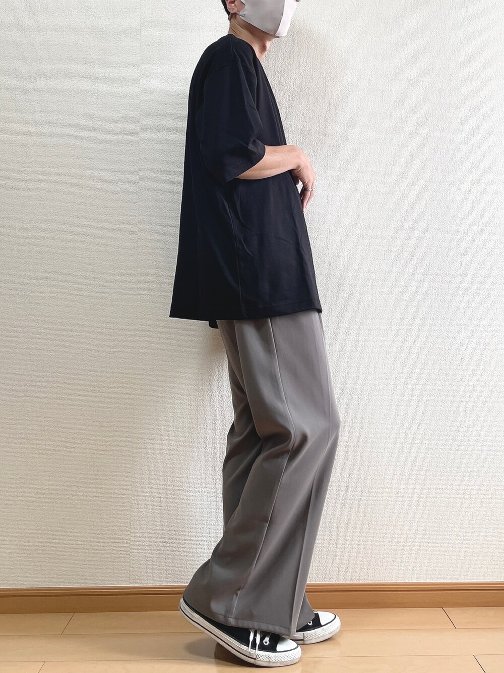 ブラック系のTシャツ/カットソー、ブラウン系のスラックス、ブラック系のスニーカーを着用したメンズの夏コーディネートの2枚目の写真