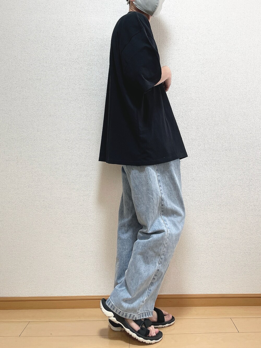 ブラック系のTシャツ/カットソー、ブルー系のデニムパンツ、ブラック系のサンダルを着用したメンズの夏コーディネートの2枚目の写真