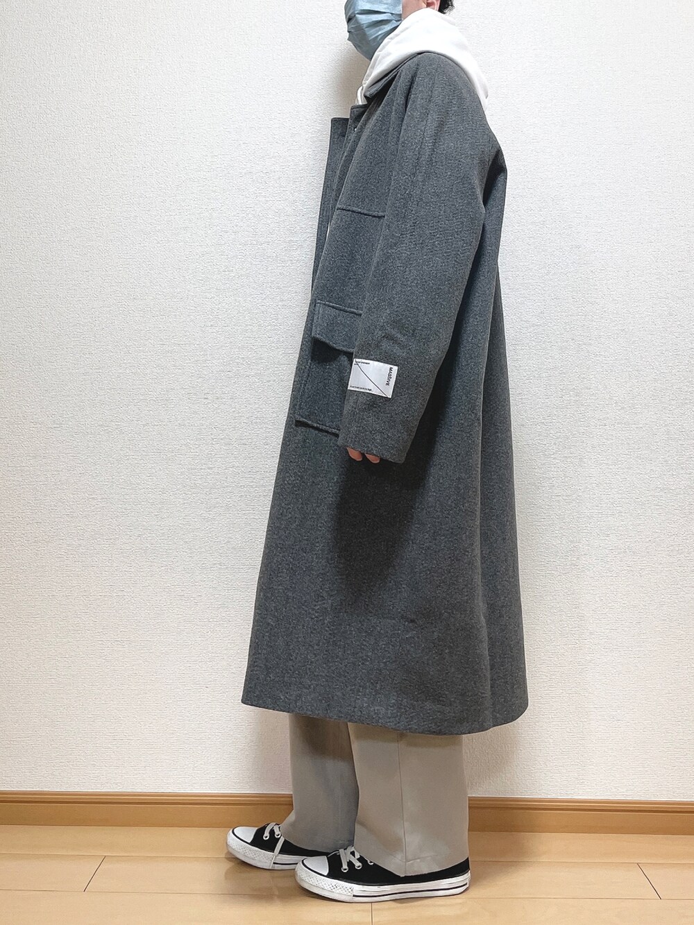 グレー系のステンカラーコート、グレー系のパーカー、ブラック系のTシャツ/カットソーを着用したメンズの冬コーディネートの4枚目の写真