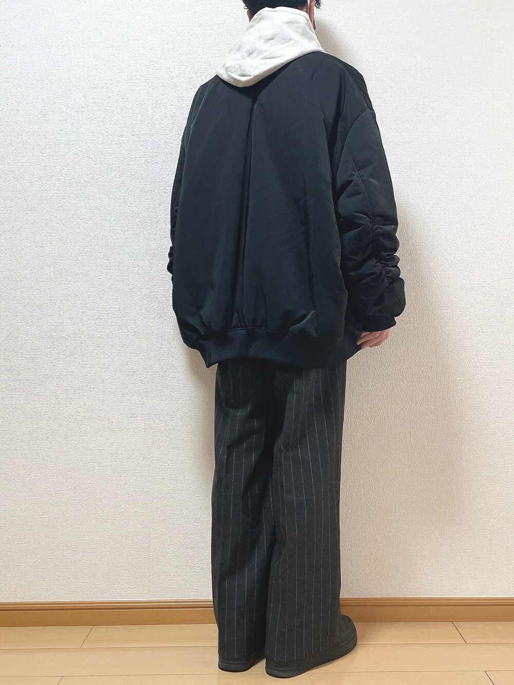 ブラック系のMA-1、グレー系のパーカー、ブラック系のTシャツ/カットソーを着用したメンズの冬コーディネートの4枚目の写真