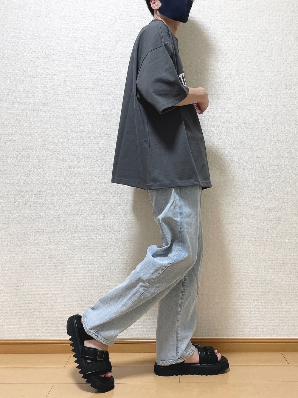 グレー系のTシャツ/カットソー、ブルー系のデニムパンツ、ブラック系のサンダルを着用したメンズの夏コーディネートの2枚目の写真