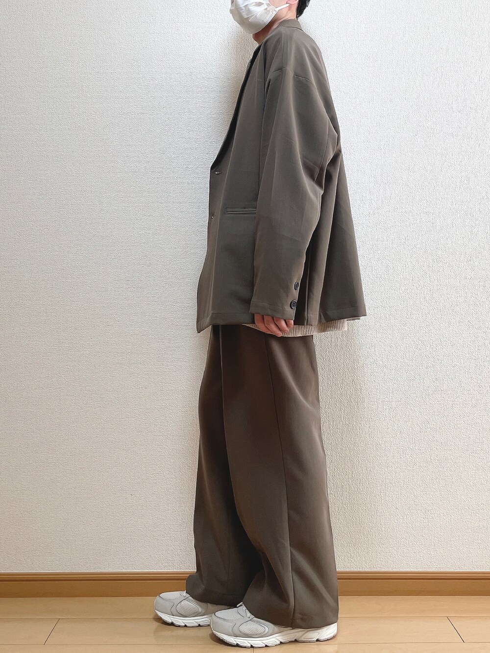 ブラウン系のテーラードジャケット、ベージュ系のニット/セーター、ホワイト系のTシャツ/カットソーを着用したメンズの春コーディネートの3枚目の写真