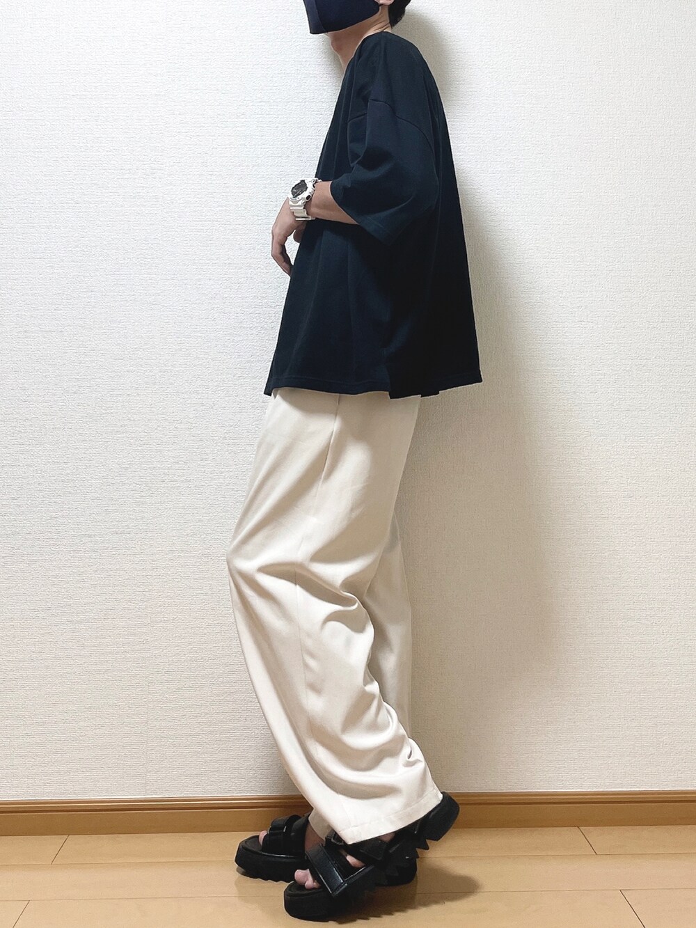 ブラック系のTシャツ/カットソー、ベージュ系のスラックス、ブラック系のサンダルを着用したメンズの夏コーディネートの3枚目の写真