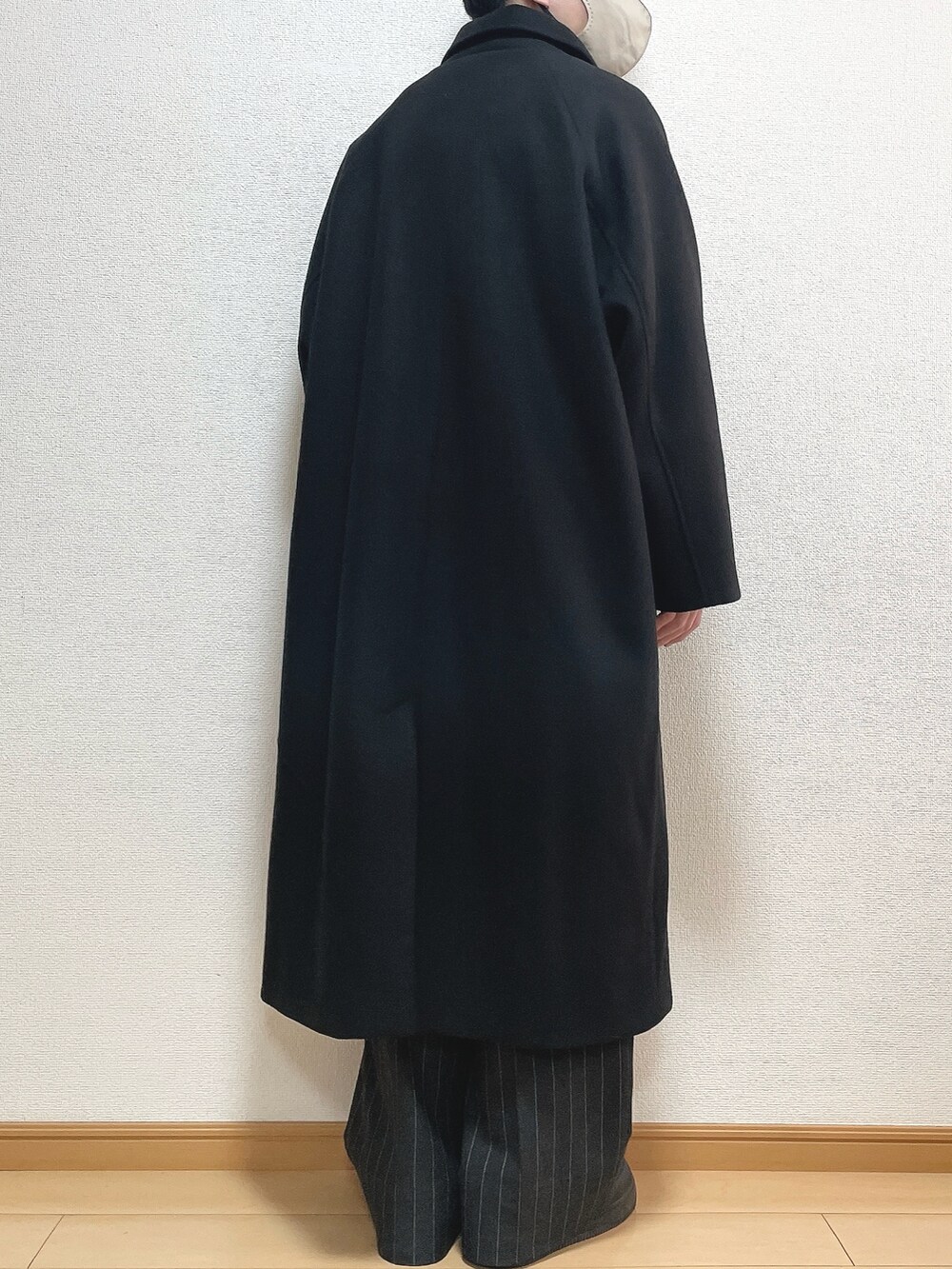 ブラック系のステンカラーコート、ブラック系のニット/セーター、ブラック系のパンツを着用したメンズの冬コーディネートの4枚目の写真