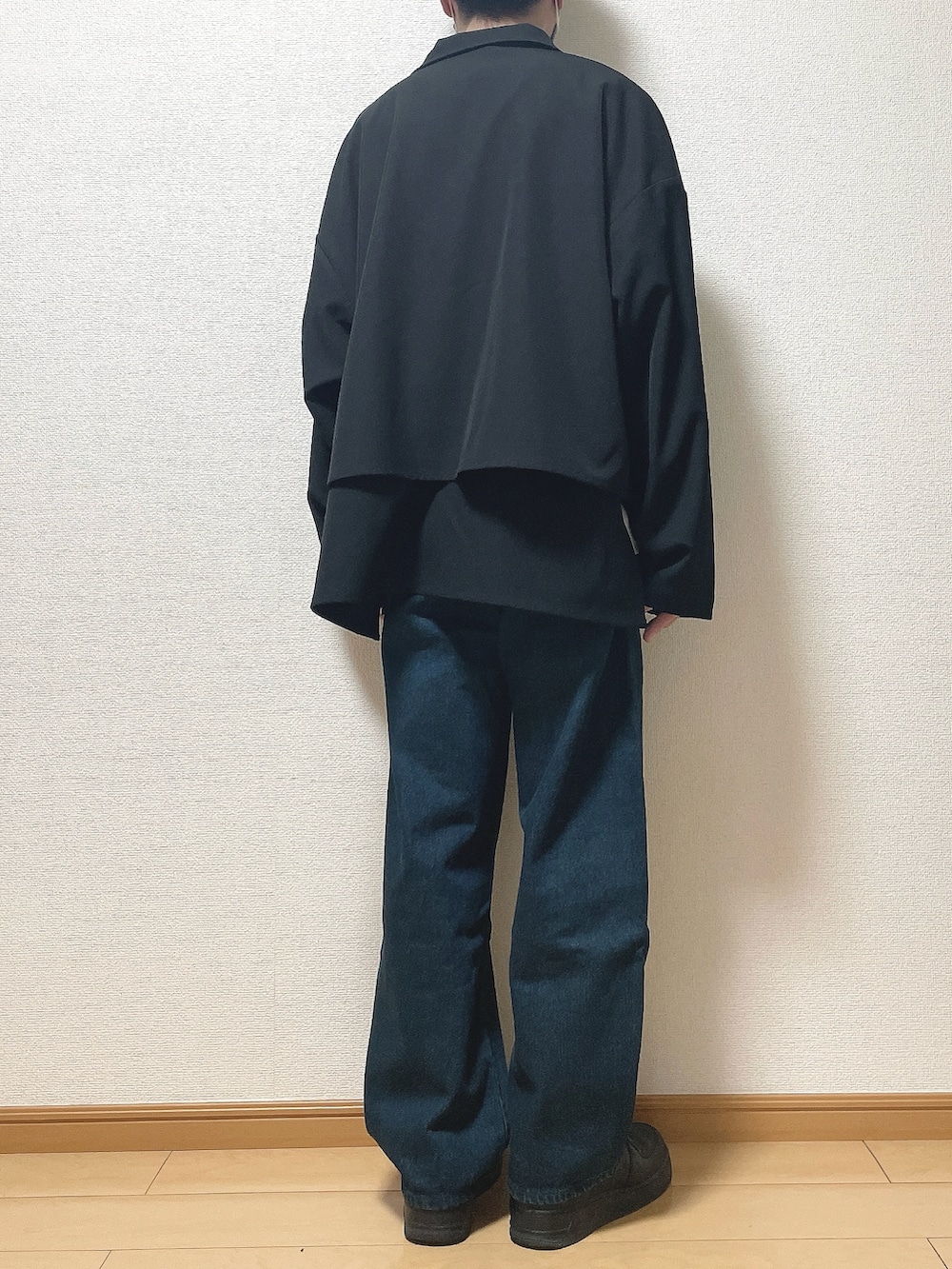 ブラック系のブルゾン、ホワイト系のTシャツ/カットソー、ブルー系のデニムパンツを着用したメンズの春コーディネートの4枚目の写真