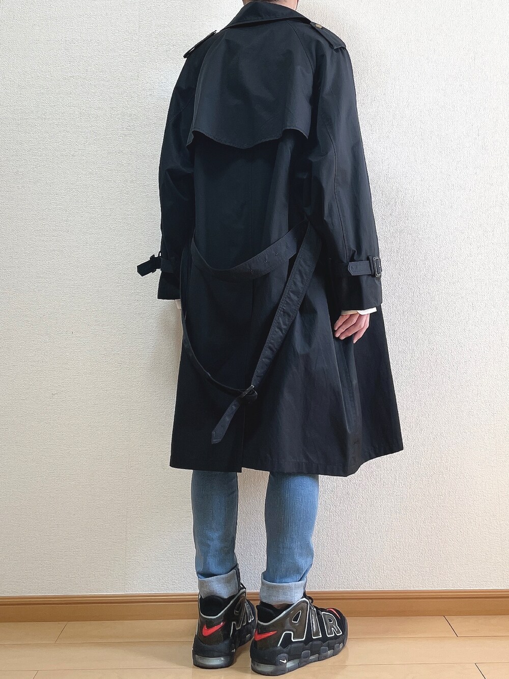 ブラック系のトレンチコート、ホワイト系のシャツ/ブラウス、ブルー系のデニムパンツを着用したメンズの春コーディネートの4枚目の写真