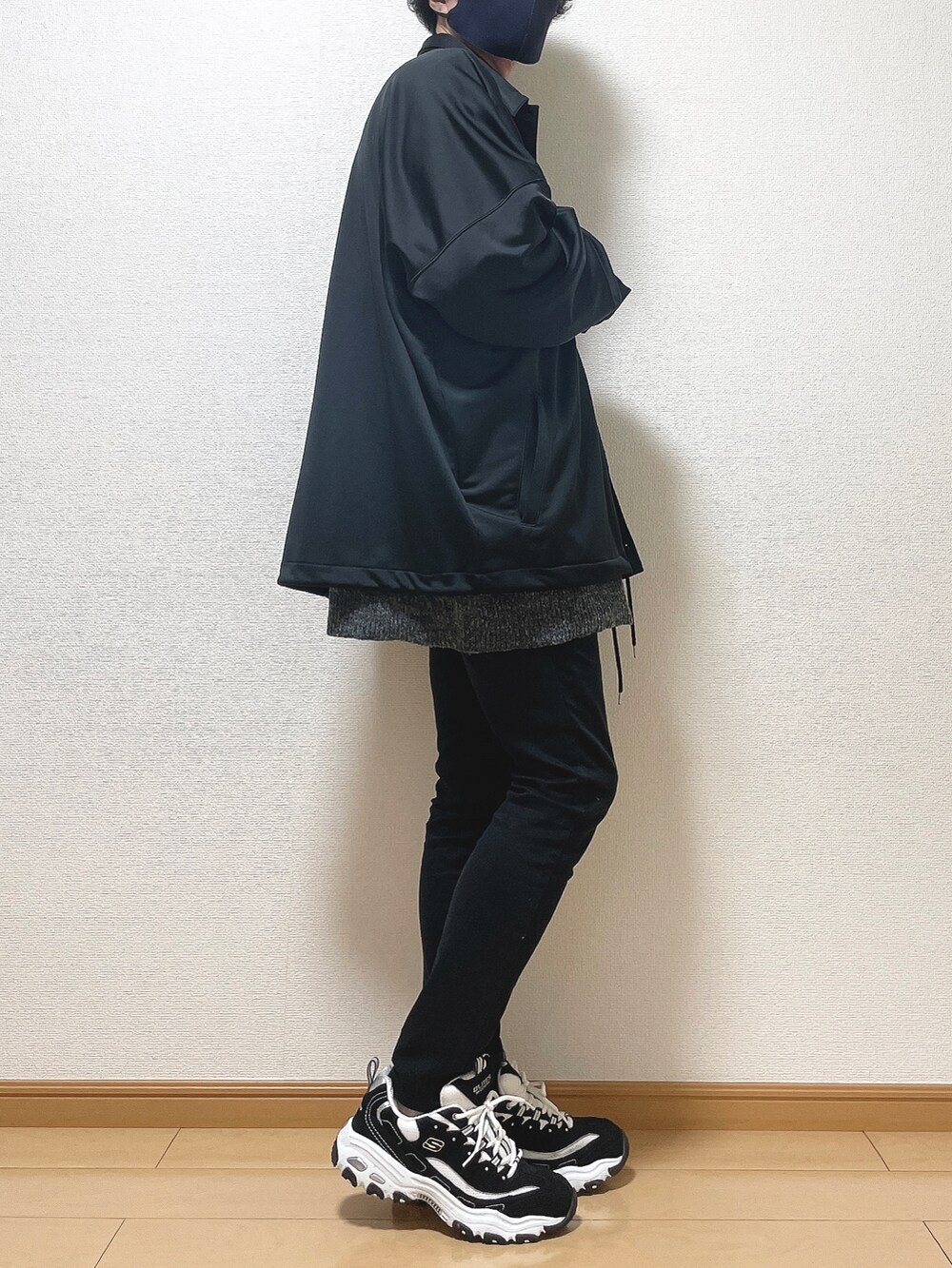 ブラック系のブルゾン、グレー系のニット/セーター、ブラック系のデニムパンツを着用したメンズの秋コーディネートの2枚目の写真