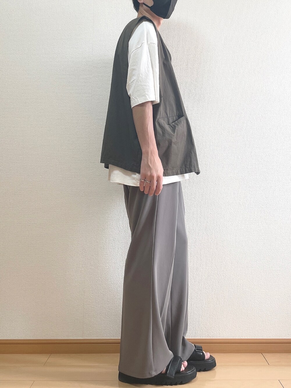 グレー系のベスト、ホワイト系のTシャツ/カットソー、ブラウン系のスラックスを着用したメンズの夏コーディネートの2枚目の写真