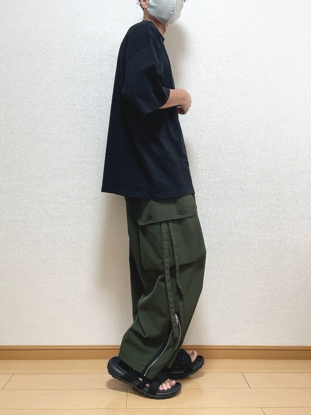 ブラック系のTシャツ/カットソー、グリーン系のカーゴパンツ、ブラック系のサンダルを着用したメンズの夏コーディネートの2枚目の写真