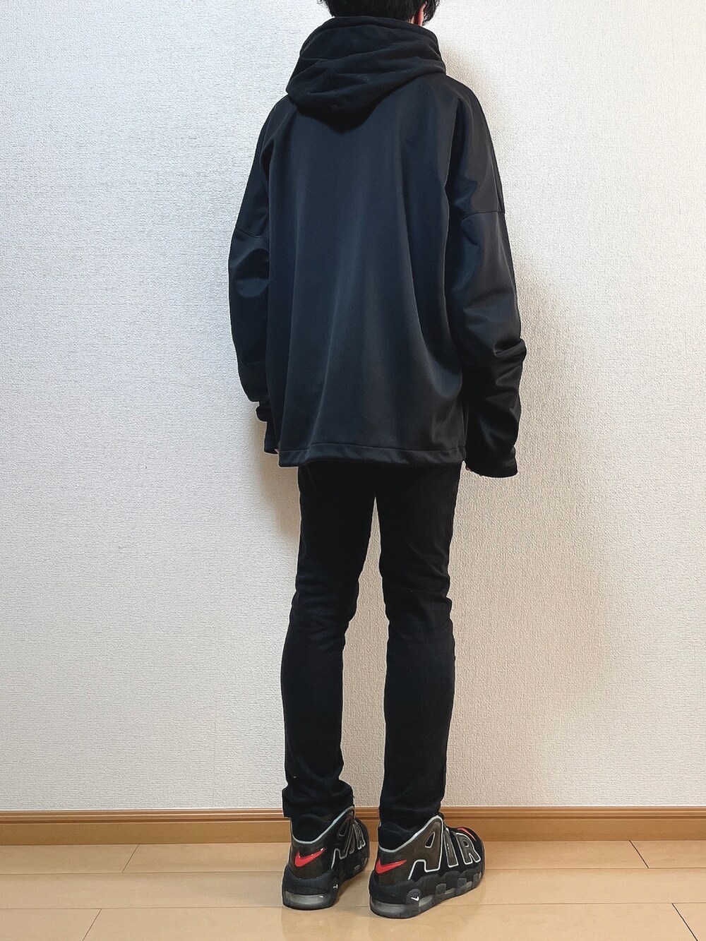 ブラック系のブルゾン、ブラック系のパーカー、ブラック系のデニムパンツを着用したメンズの冬コーディネートの4枚目の写真