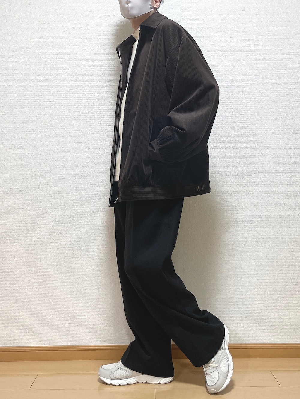 ブラウン系のブルゾン、ホワイト系のTシャツ/カットソー、ブラック系のその他パンツを着用したメンズの冬コーディネートの2枚目の写真