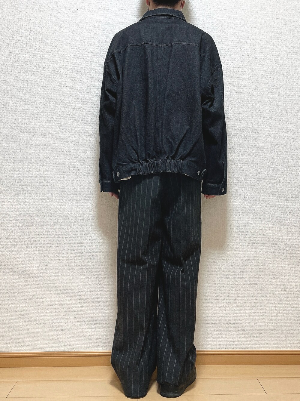 ブラック系のデニムジャケット、ホワイト系のTシャツ/カットソー、ブラック系のパンツを着用したメンズの秋コーディネートの4枚目の写真