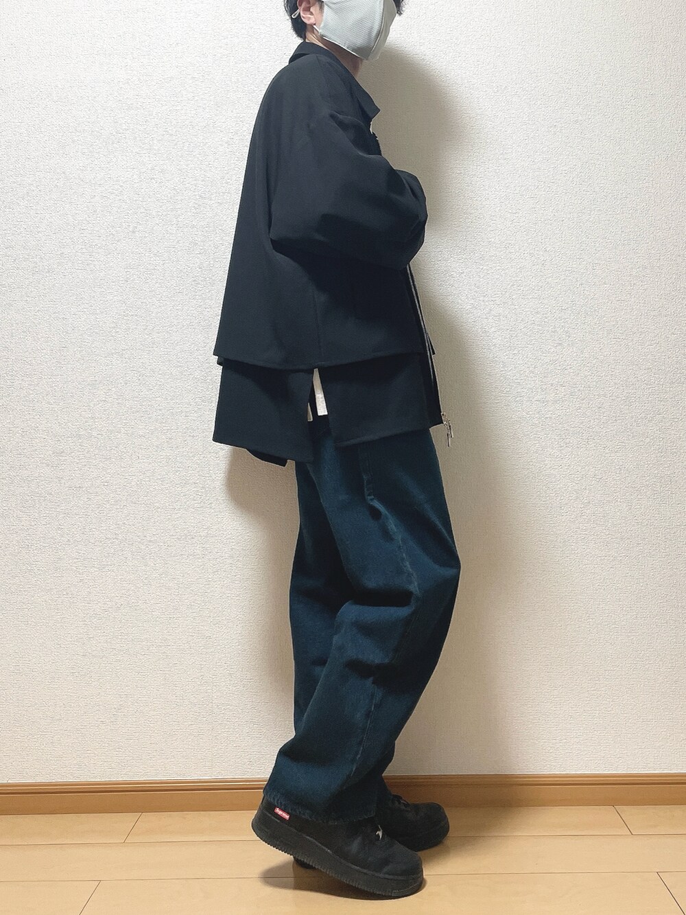 ブラック系のブルゾン、ホワイト系のTシャツ/カットソー、ブルー系のデニムパンツを着用したメンズの春コーディネートの2枚目の写真