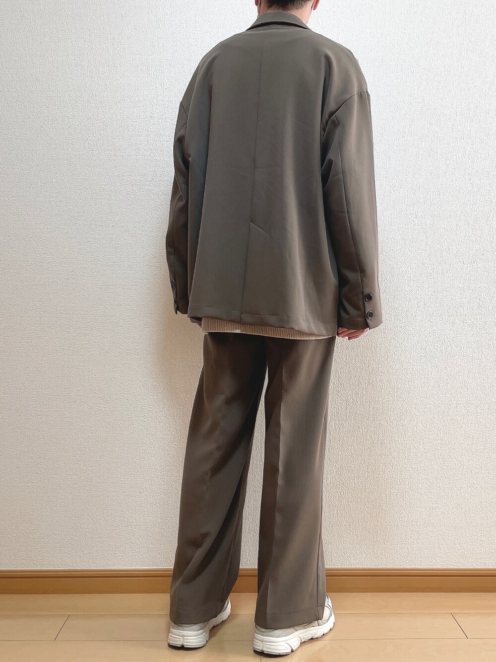 ブラウン系のテーラードジャケット、ベージュ系のニット/セーター、ホワイト系のTシャツ/カットソーを着用したメンズの春コーディネートの4枚目の写真