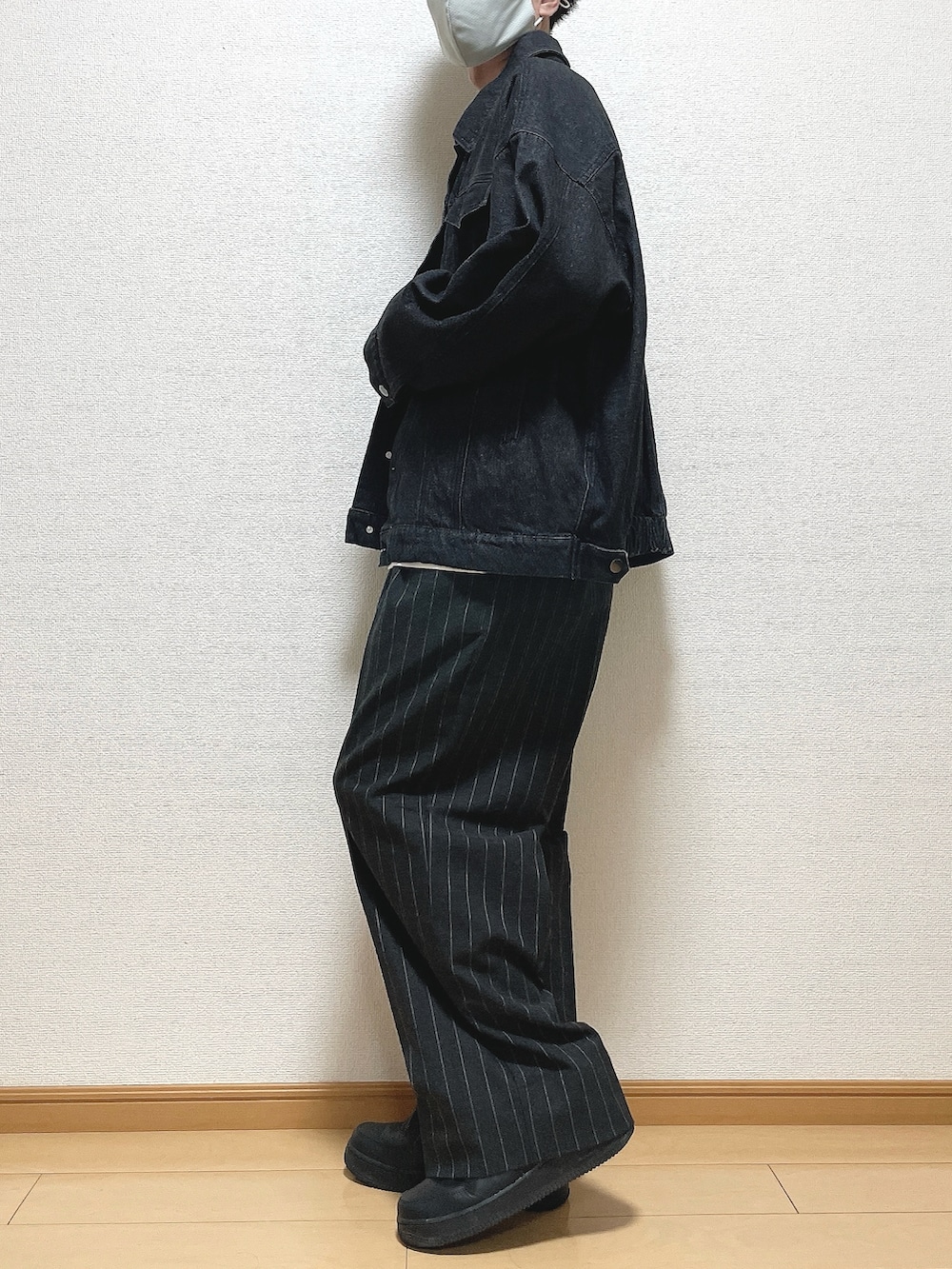 ブラック系のデニムジャケット、ホワイト系のTシャツ/カットソー、ブラック系のパンツを着用したメンズの秋コーディネートの3枚目の写真