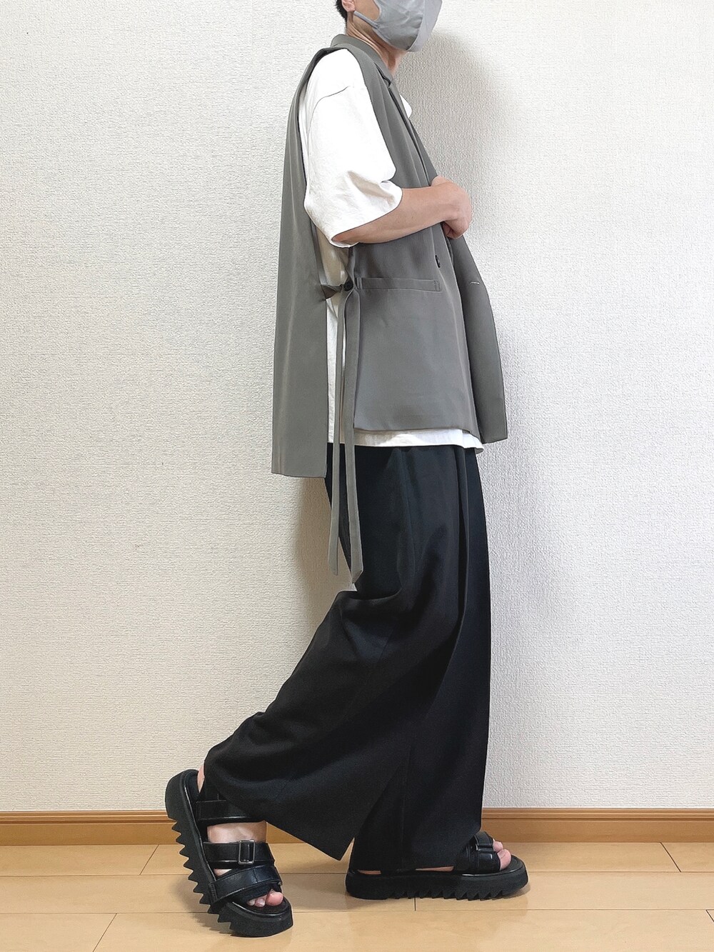 グレー系のベスト、ホワイト系のTシャツ/カットソー、ブラック系のスラックスを着用したメンズの夏コーディネートの3枚目の写真