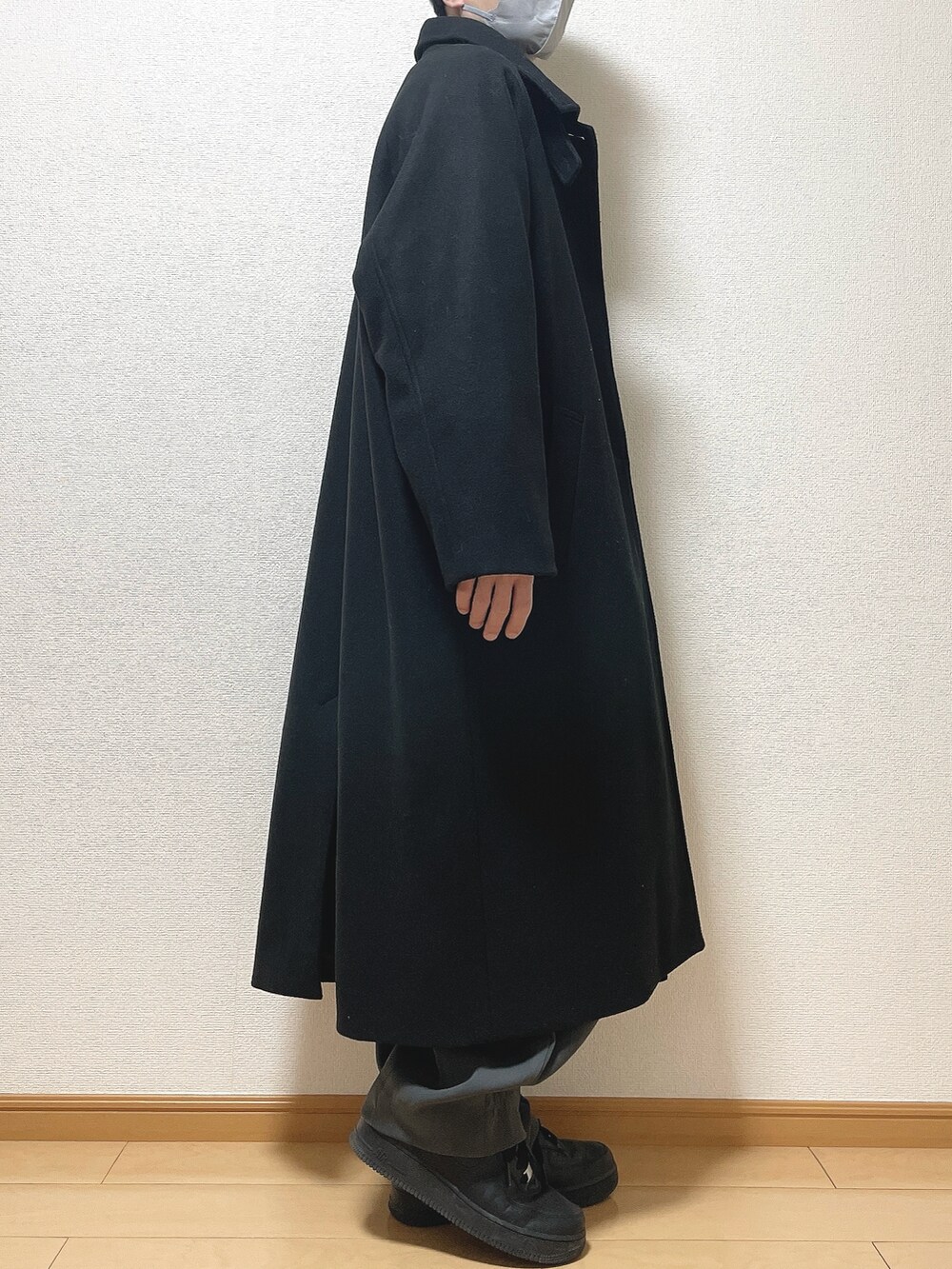 ブラック系のステンカラーコート、ブラウン系のシャツ/ブラウス、ブラック系のTシャツ/カットソーを着用したメンズの冬コーディネートの2枚目の写真