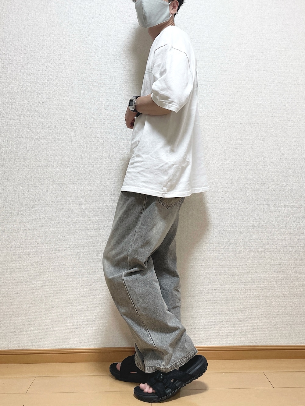 グリーン系のTシャツ/カットソー、ブラック系のデニムパンツ、ブラック系のサンダルを着用したメンズの夏コーディネートの3枚目の写真