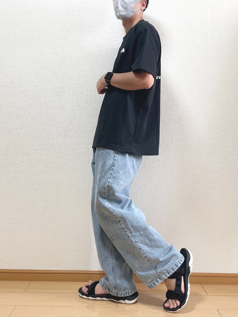 ブラック系のTシャツ/カットソー、ブルー系のデニムパンツ、ブラック系のサンダルを着用したメンズの夏コーディネートの3枚目の写真