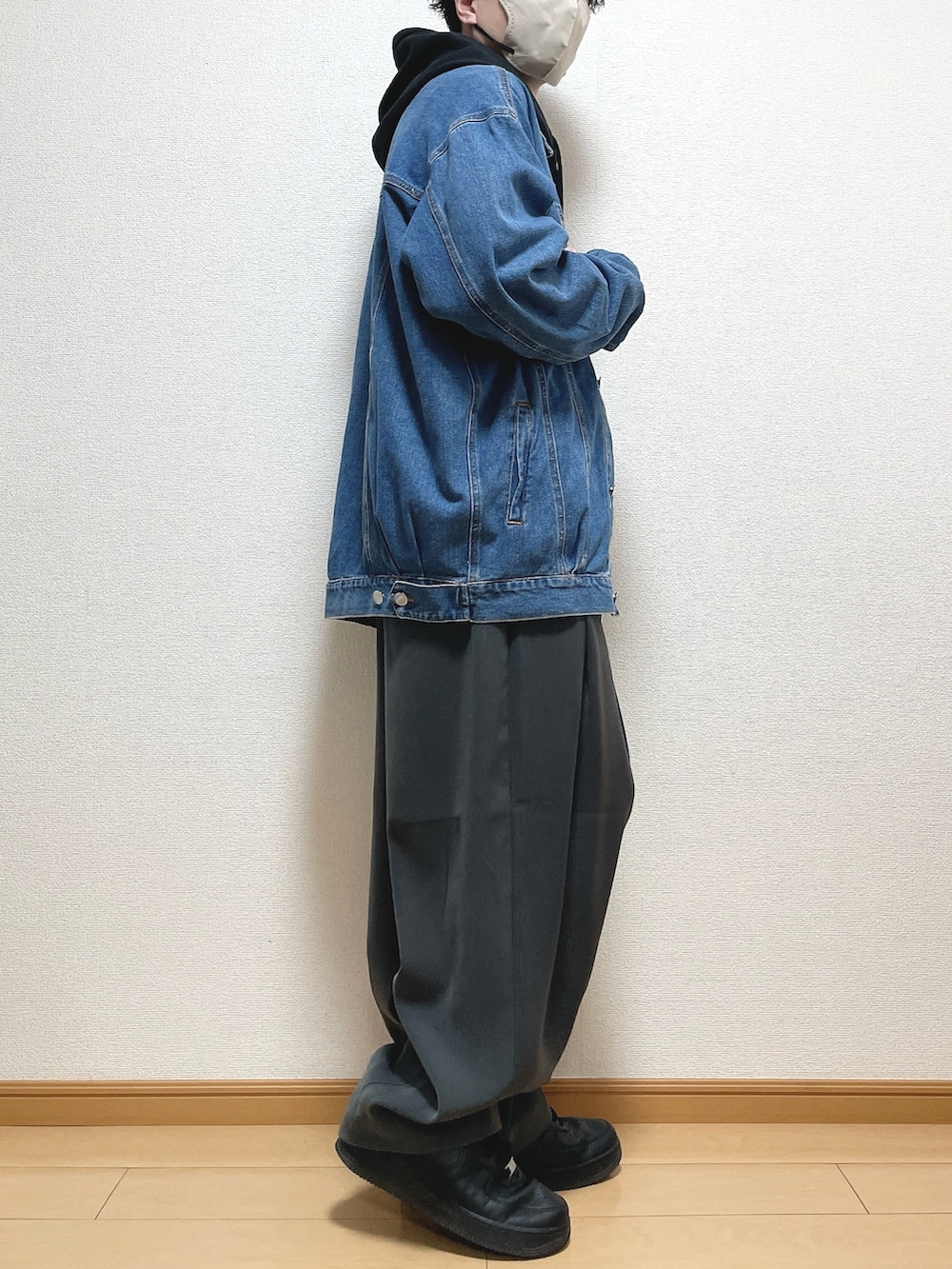 ブラック系のパーカー、グレー系のスラックス、ブラック系のスニーカーを着用したメンズの春コーディネートの2枚目の写真