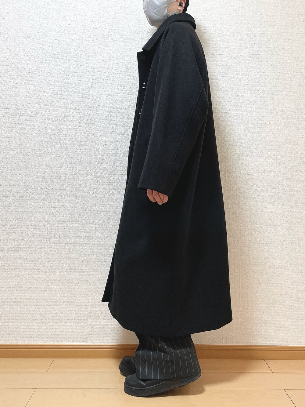 ブラック系のステンカラーコート、グレー系のスウェット、ブラック系のパンツを着用したメンズの冬コーディネートの3枚目の写真