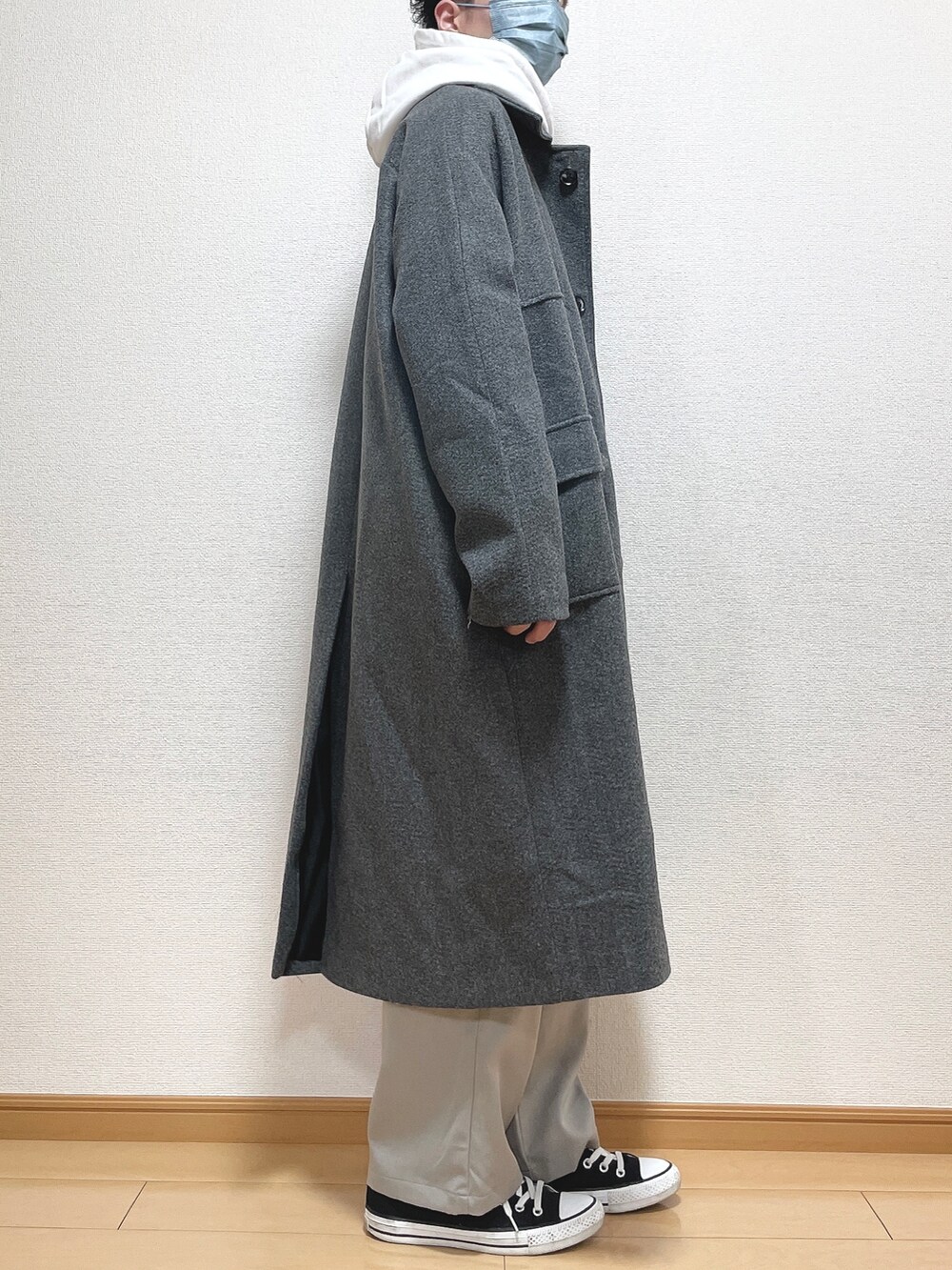 グレー系のステンカラーコート、グレー系のパーカー、ブラック系のTシャツ/カットソーを着用したメンズの冬コーディネートの2枚目の写真