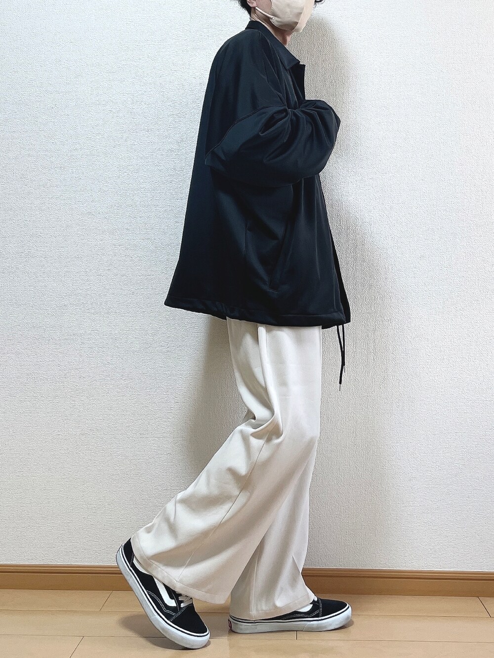 ブラック系のブルゾン、ブラック系のTシャツ/カットソー、ベージュ系のスラックスを着用したメンズの冬コーディネートの2枚目の写真