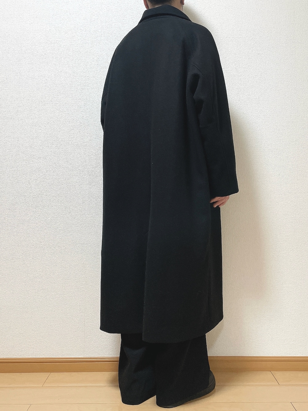 ブラック系のステンカラーコート、ブラック系のニット/セーター、ブラック系のその他パンツを着用したメンズの冬コーディネートの4枚目の写真