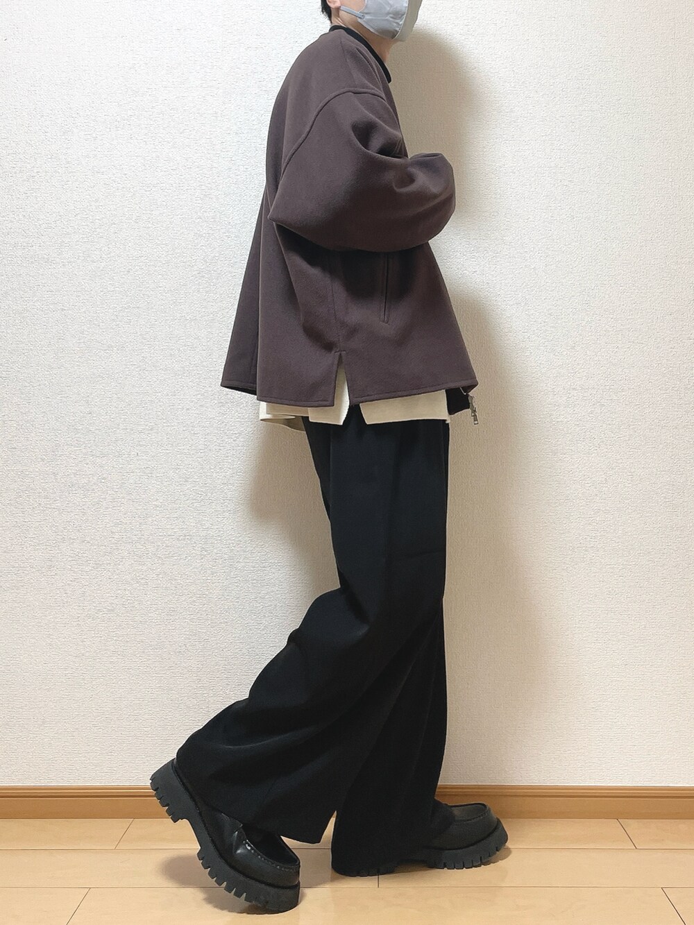 レッド系のブルゾン、ホワイト系のニット/セーター、ブラック系のTシャツ/カットソーを着用したメンズの冬コーディネートの2枚目の写真