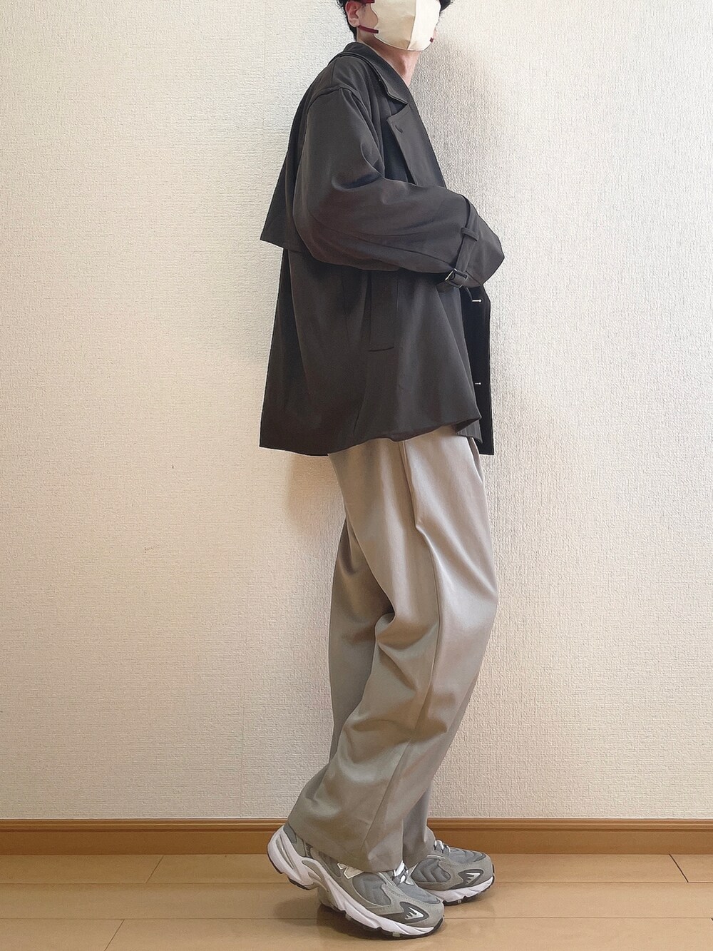 ブラウン系のトレンチコート、ブラウン系のニット/セーター、グレー系のその他パンツを着用したメンズの冬コーディネートの2枚目の写真