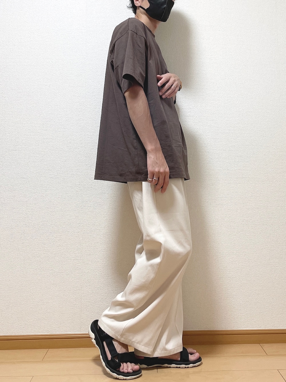 ブラウン系のTシャツ/カットソー、ベージュ系のスラックス、ブラック系のサンダルを着用したメンズの夏コーディネートの2枚目の写真