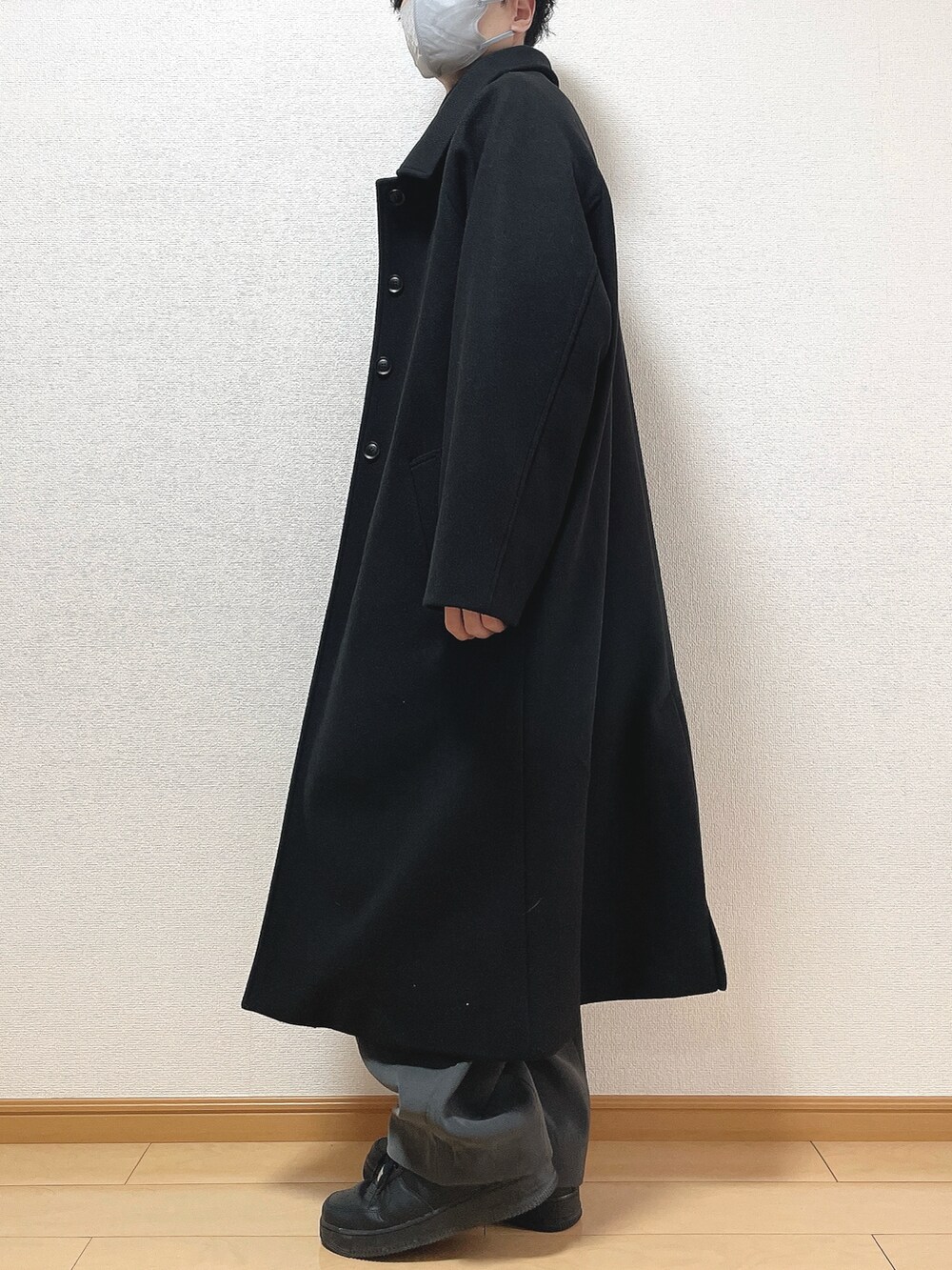 ブラック系のステンカラーコート、ブラック系のスウェット、グレー系のTシャツ/カットソーを着用したメンズの冬コーディネートの3枚目の写真