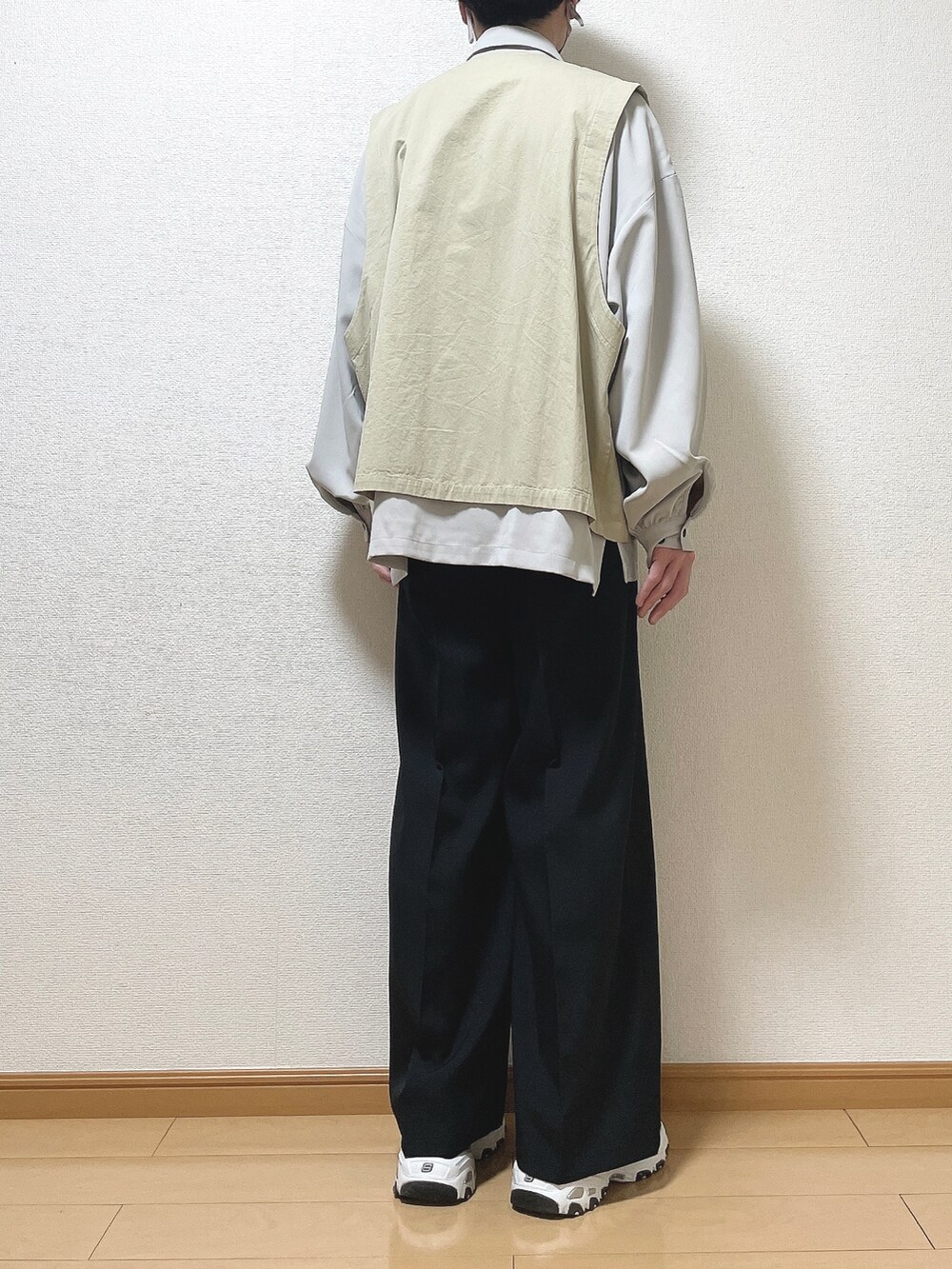 ベージュ系のベスト、グレー系のシャツ/ブラウス、ブラック系のスラックスを着用したメンズの春コーディネートの4枚目の写真