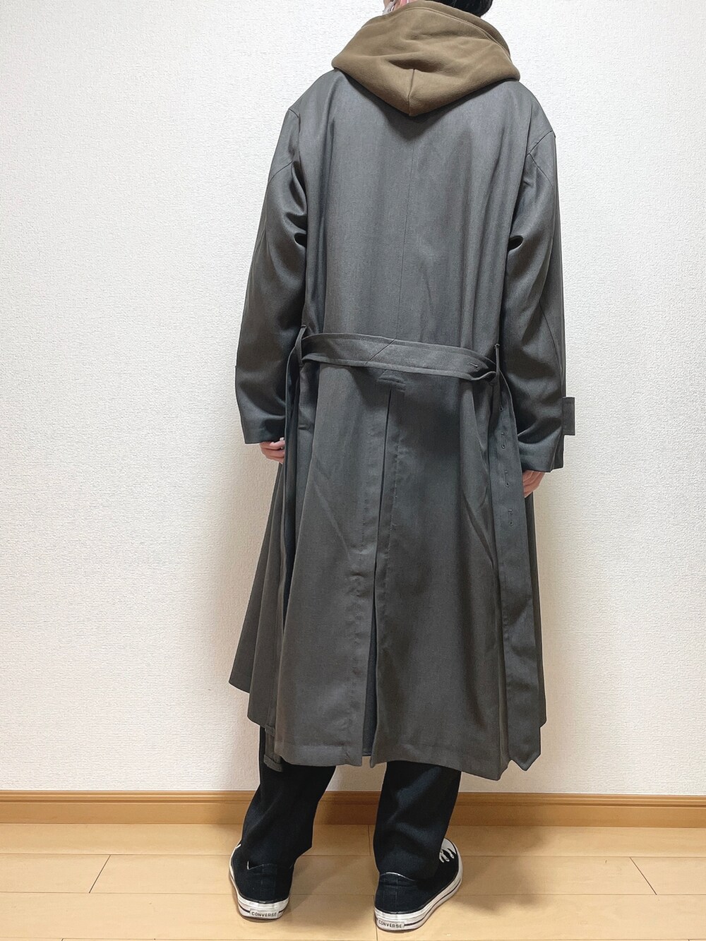 グレー系のトレンチコート、ブラウン系のパーカー、ブラック系のスラックスを着用したメンズの冬コーディネートの4枚目の写真