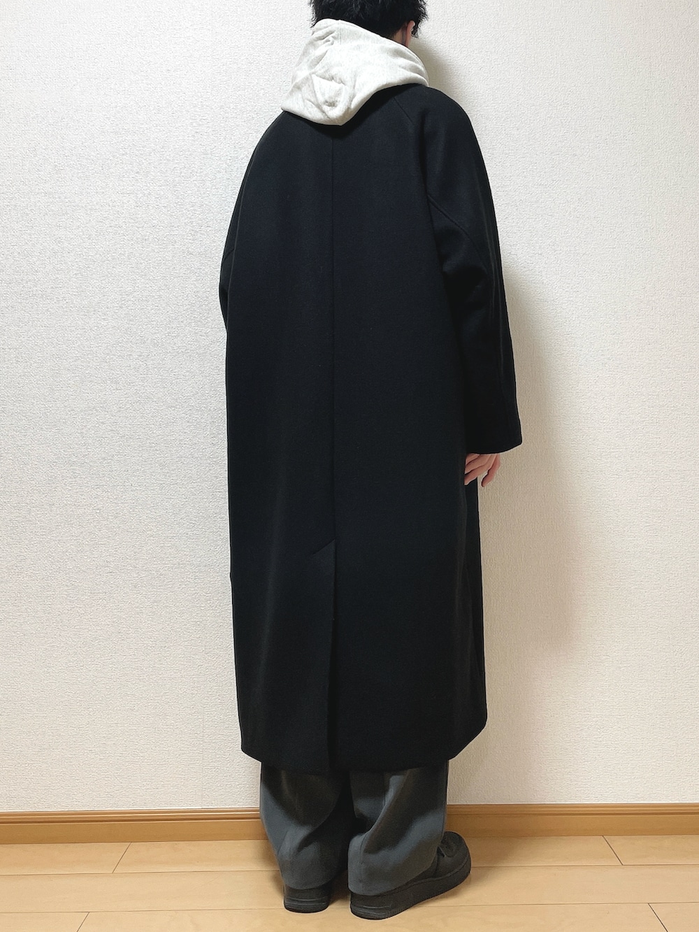ブラック系のステンカラーコート、グレー系のパーカー、グレー系のTシャツ/カットソーを着用したメンズの冬コーディネートの4枚目の写真