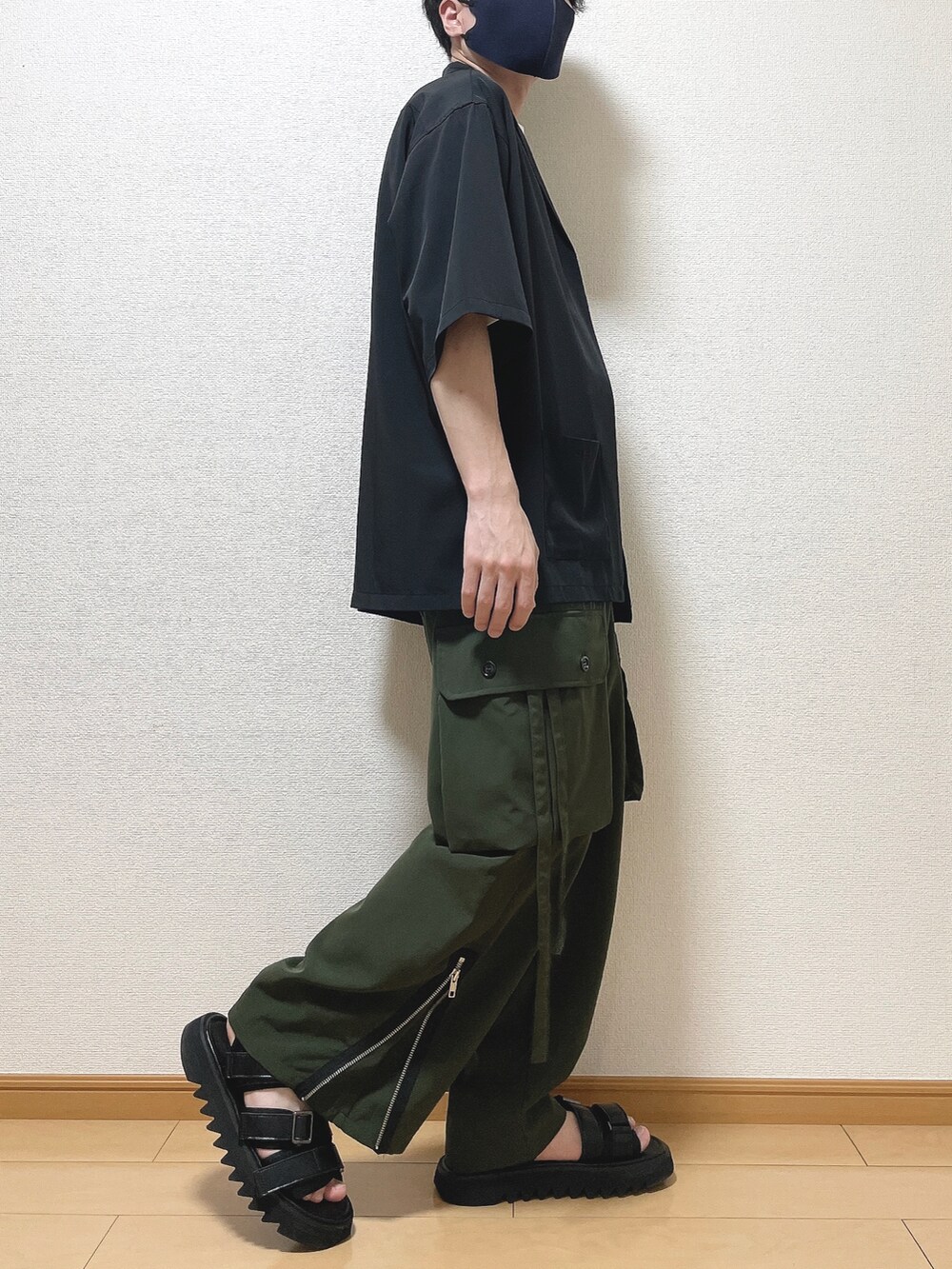 ブラック系のジャケット/アウター、ホワイト系のTシャツ/カットソー、グリーン系のカーゴパンツを着用したメンズの春コーディネートの2枚目の写真