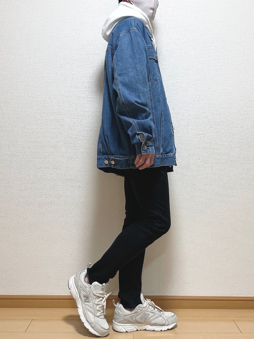 ブルー系のデニムジャケット、ブラック系のデニムパンツ、ホワイト系のスニーカーを着用したメンズの春コーディネートの2枚目の写真