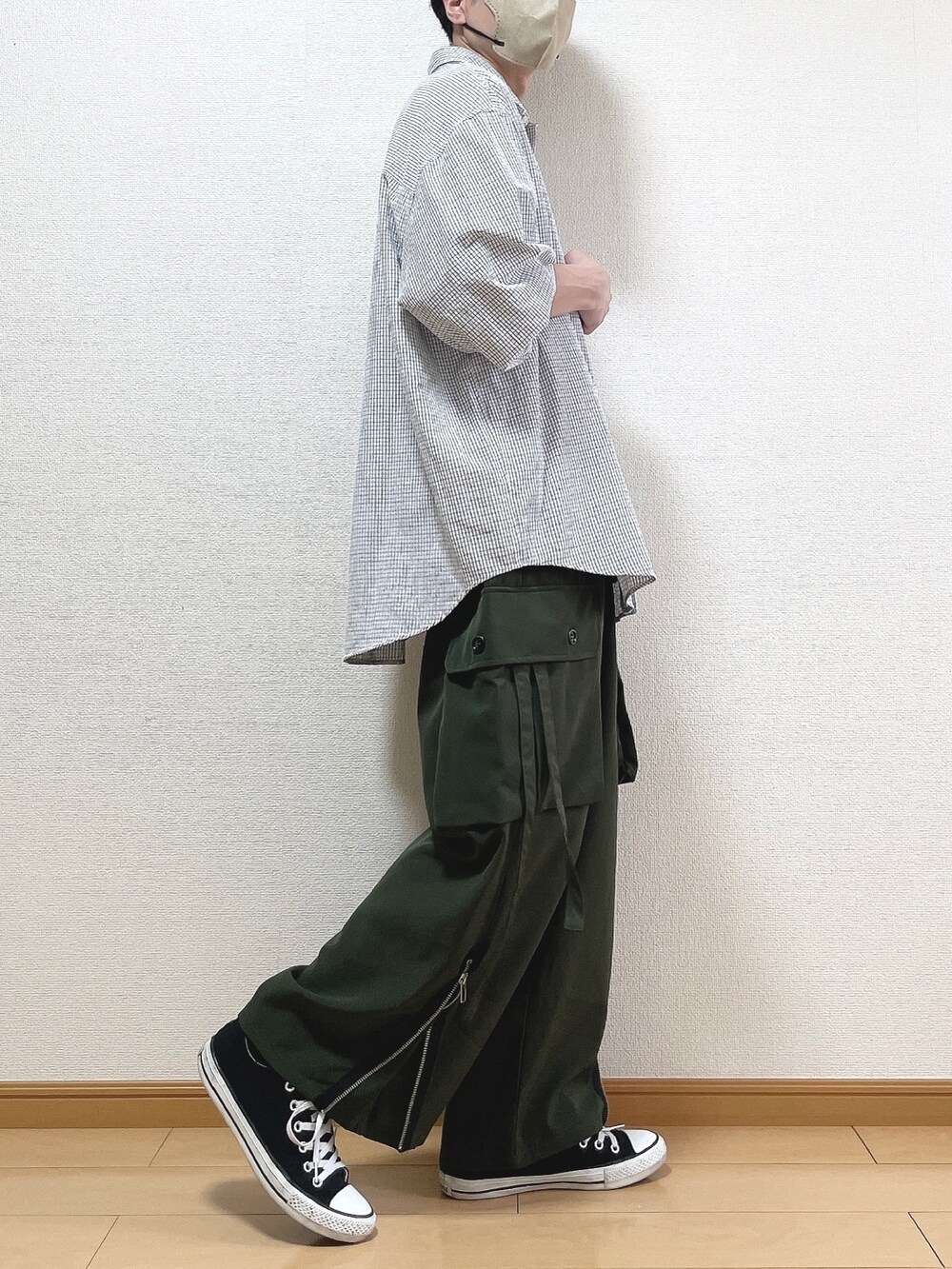 ブラック系のシャツ/ブラウス、グリーン系のカーゴパンツ、ブラック系のスニーカーを着用したメンズの春コーディネートの2枚目の写真