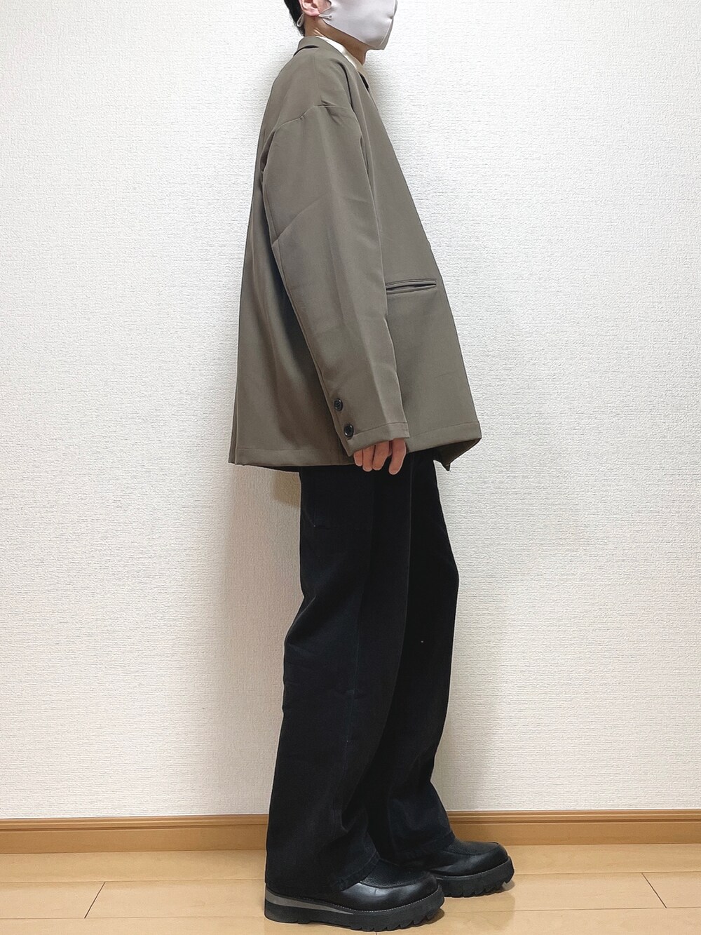 ブラウン系のテーラードジャケット、ホワイト系のTシャツ/カットソー、ブラック系のデニムパンツを着用したメンズの冬コーディネートの2枚目の写真