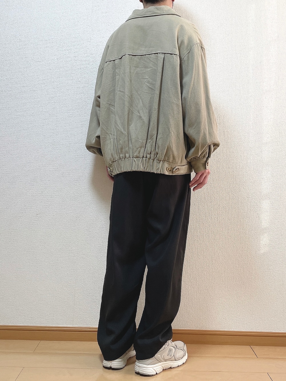 ベージュ系のブルゾン、ホワイト系のスウェット、グレー系のセットアップを着用したメンズの冬コーディネートの4枚目の写真