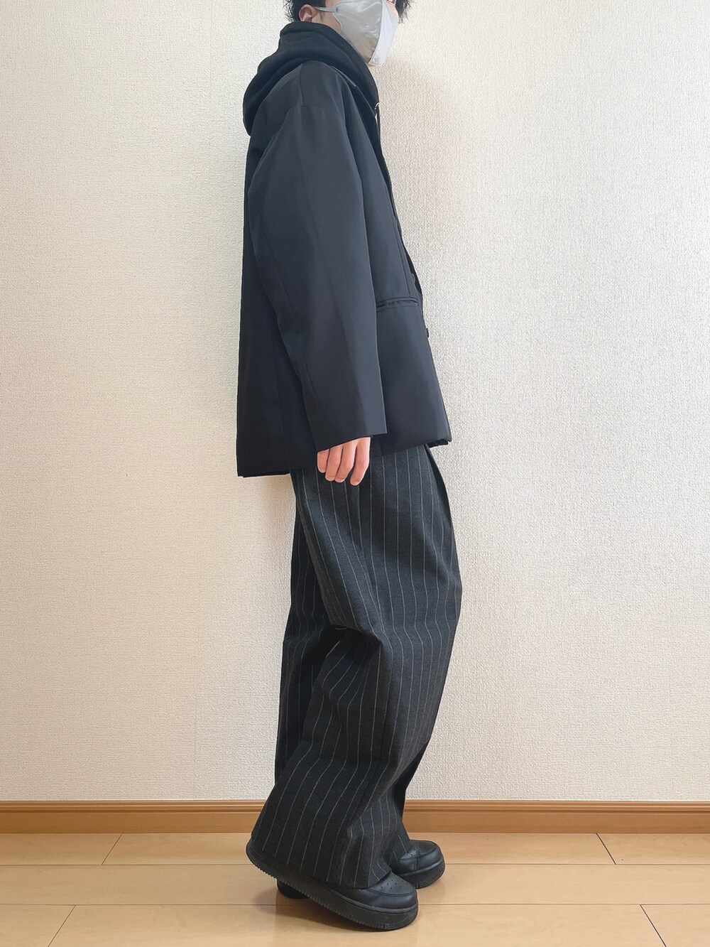 ブラック系のテーラードジャケット、ブラック系のパーカー、ブラック系のパンツを着用したメンズの冬コーディネートの2枚目の写真