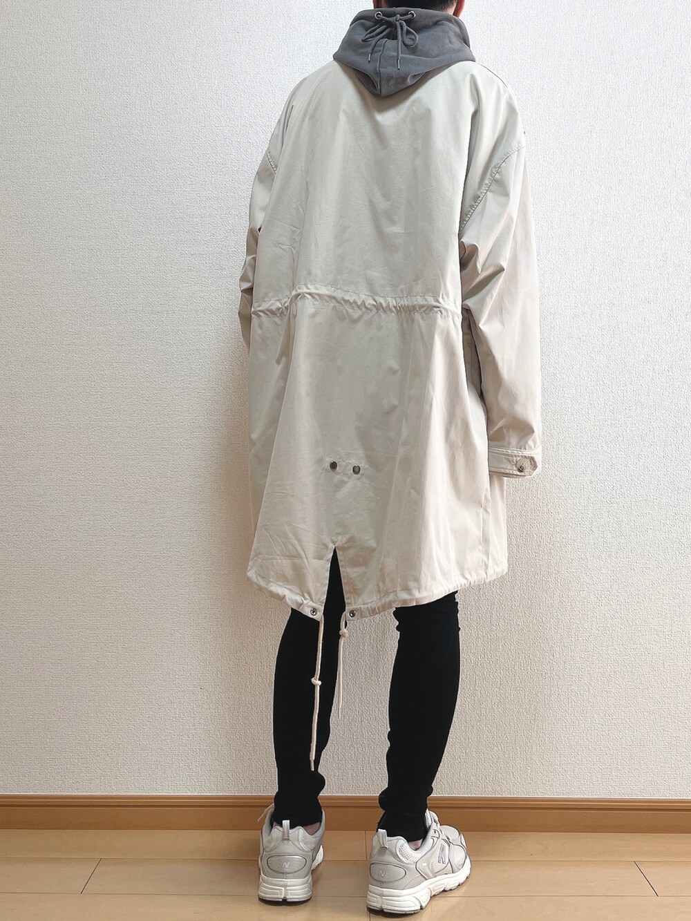 ベージュ系のモッズコート、グレー系のパーカー、ブラック系のデニムパンツを着用したメンズの春コーディネートの4枚目の写真