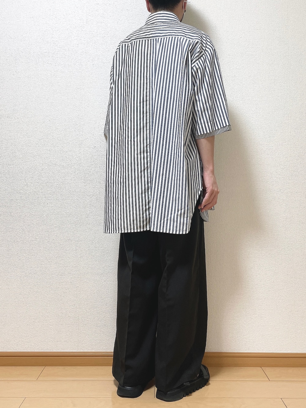 ホワイト系のシャツ/ブラウス、ブラック系のスラックス、ブラック系のサンダルを着用したメンズの夏コーディネートの4枚目の写真