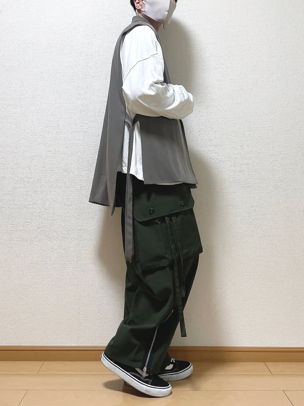 ブラウン系のベスト、ホワイト系のTシャツ/カットソー、グリーン系のカーゴパンツを着用したメンズの春コーディネートの2枚目の写真